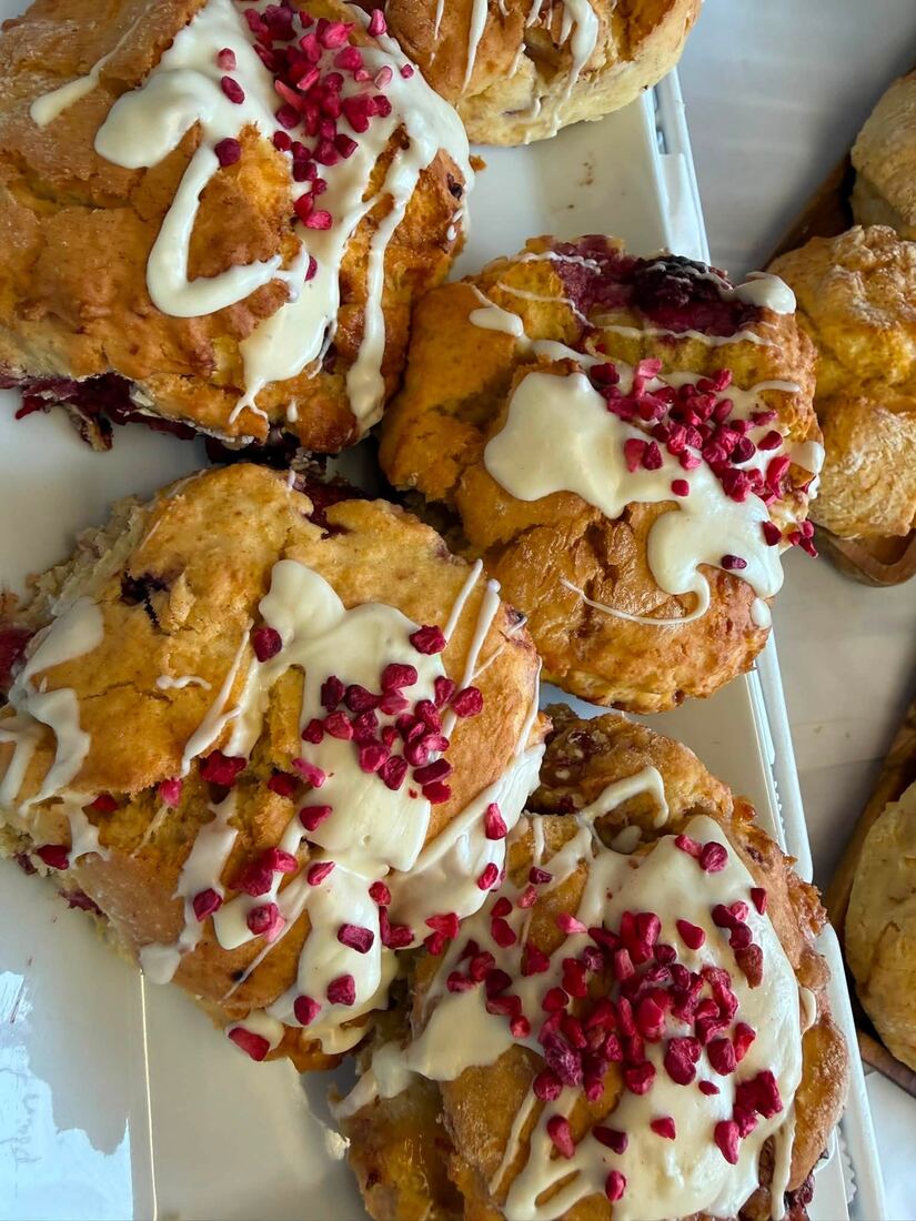 Chocolate swirl pastries dusted with icing sugar on a bakery tray